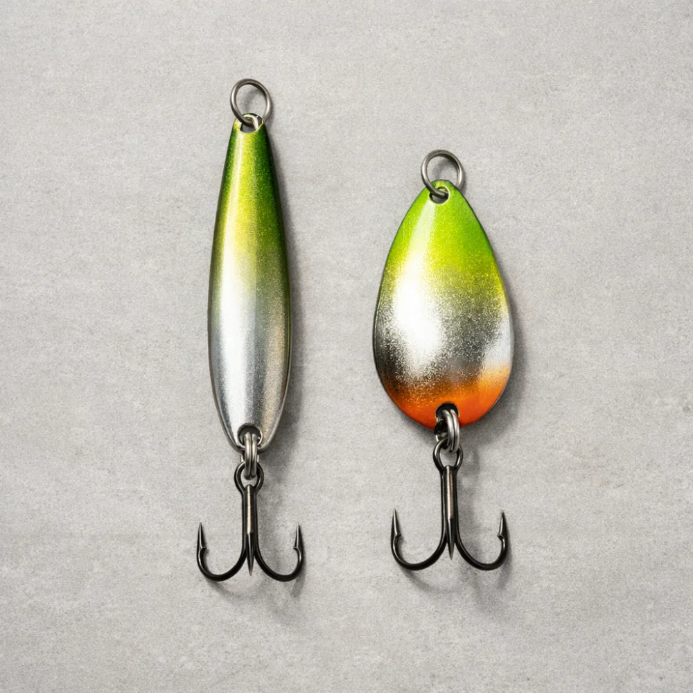 Two unbranded fishing spoons with different shapes on a neutral background